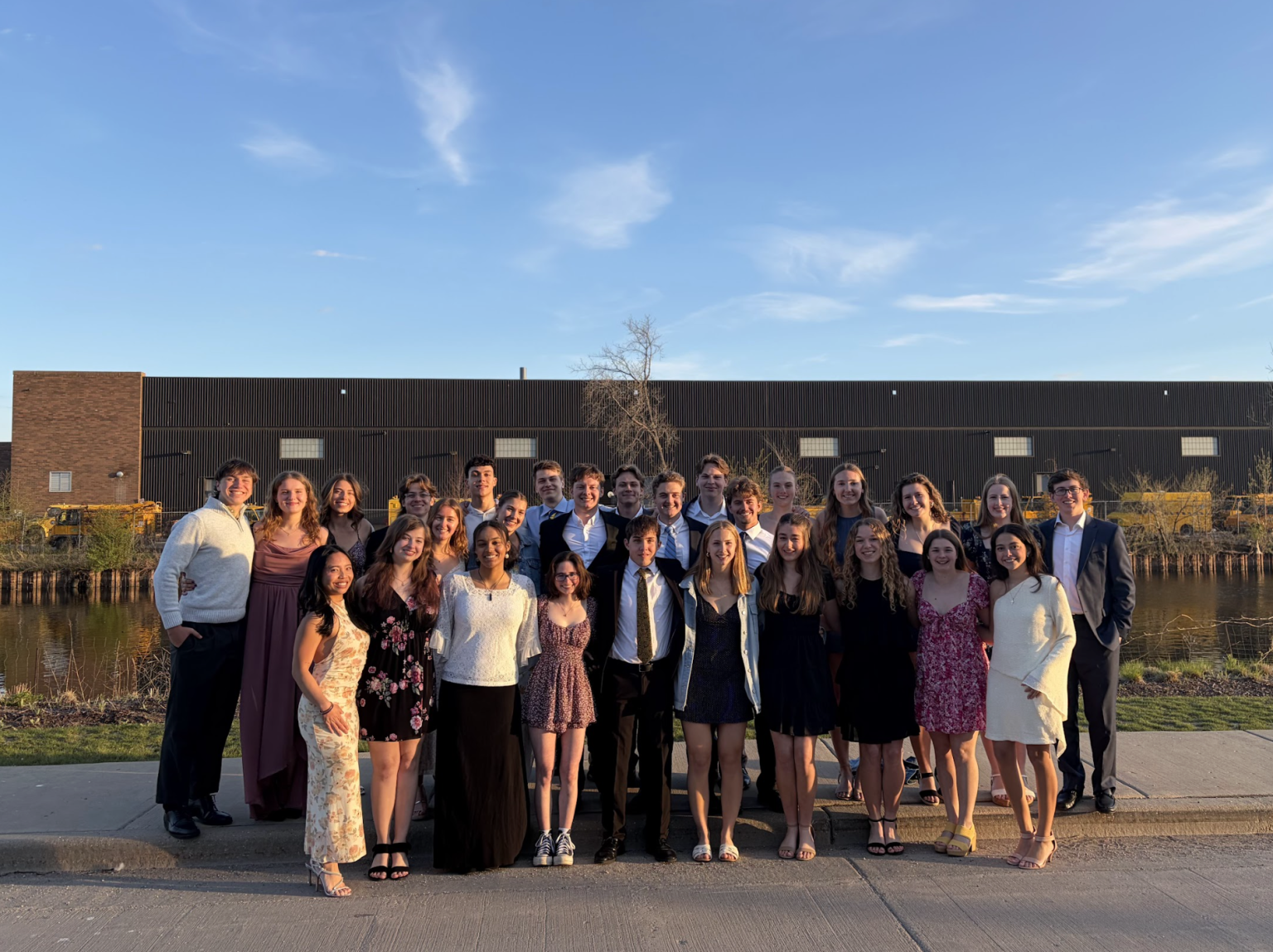 The team dressed up at the winter formal along the river at golden hour.