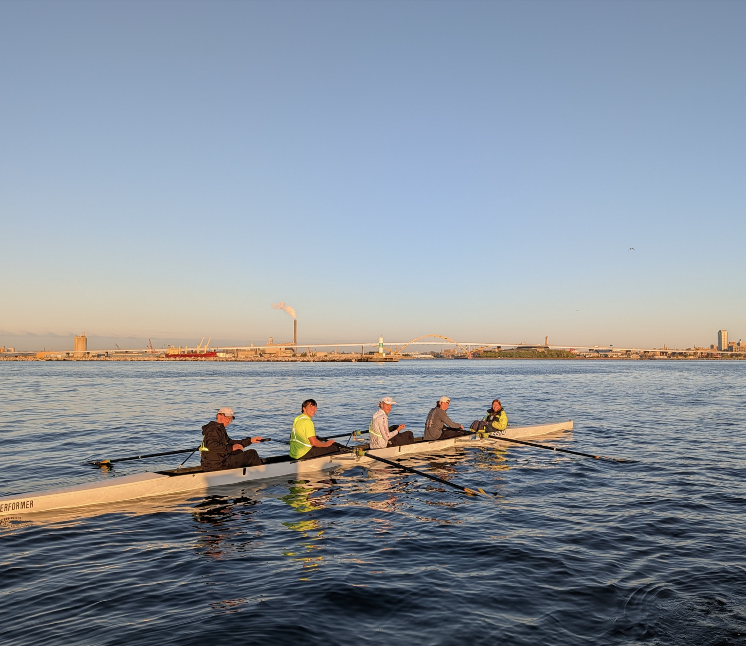A Marquette four rows on Lake Michigan beneath the Hoan Bridge, downtown Milwaukee behind them.