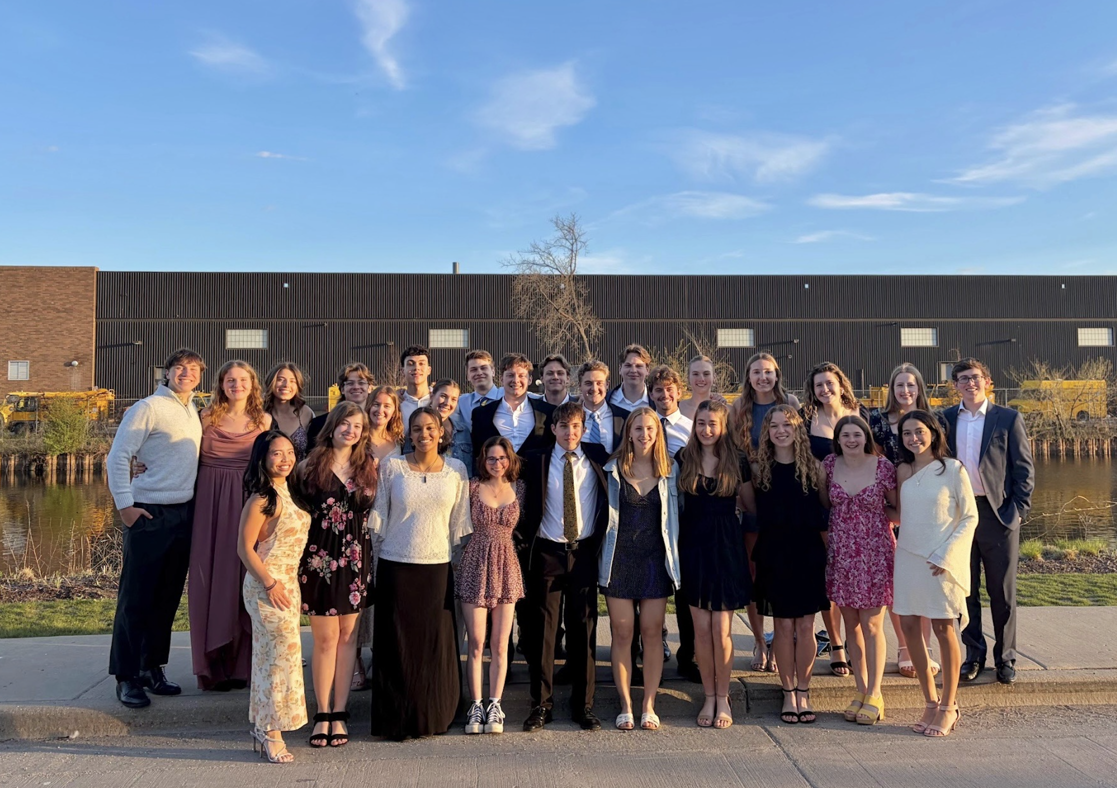 The team dressed up at the winter formal along the river at golden hour.